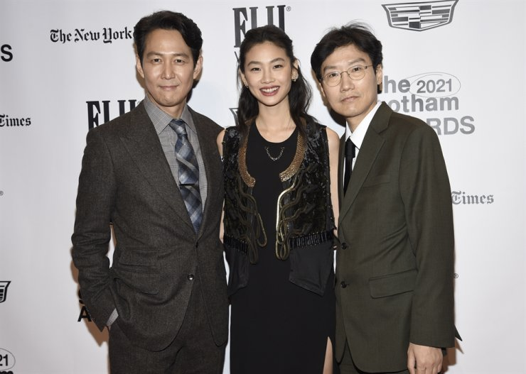 Lee Jung-jae, Jung Ho-yeon et le réalisateur Hwang Dong-hyuk présents aux Gotham Awards, posant sur le tapis rouge.