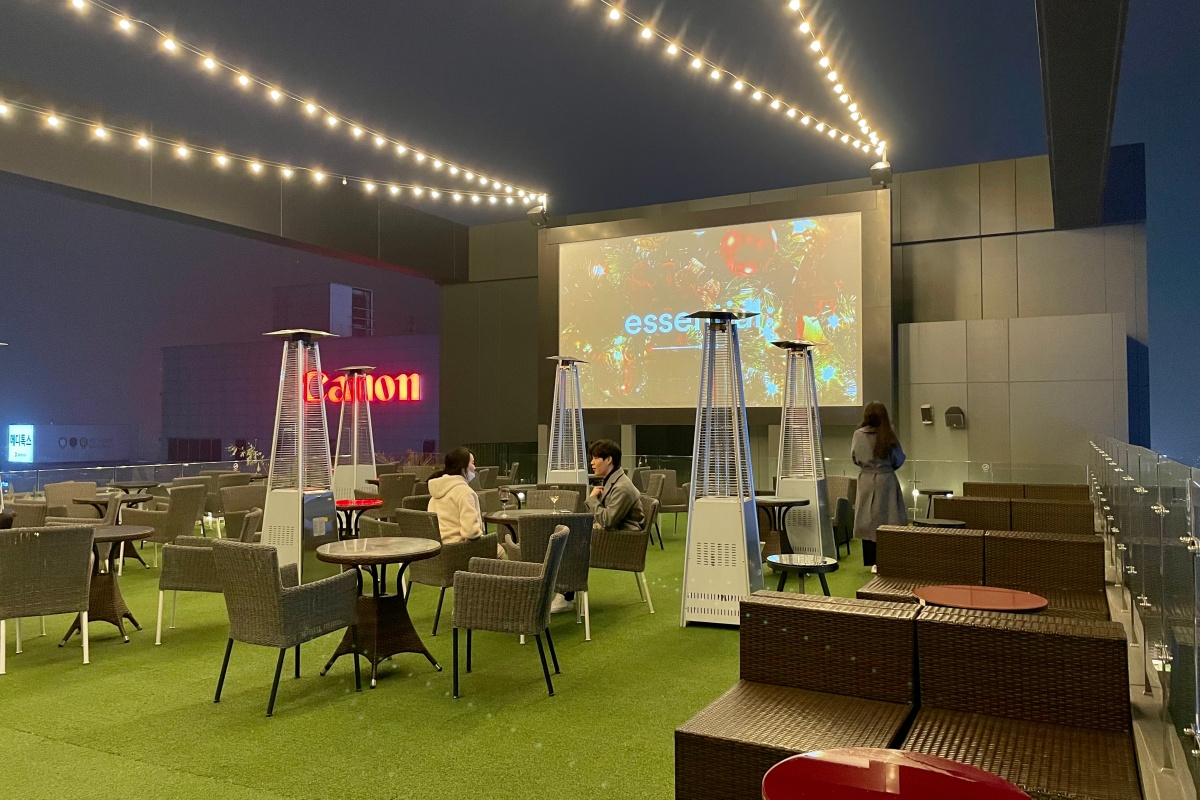 An outside terrace with string lights and a projector to decorate the location.