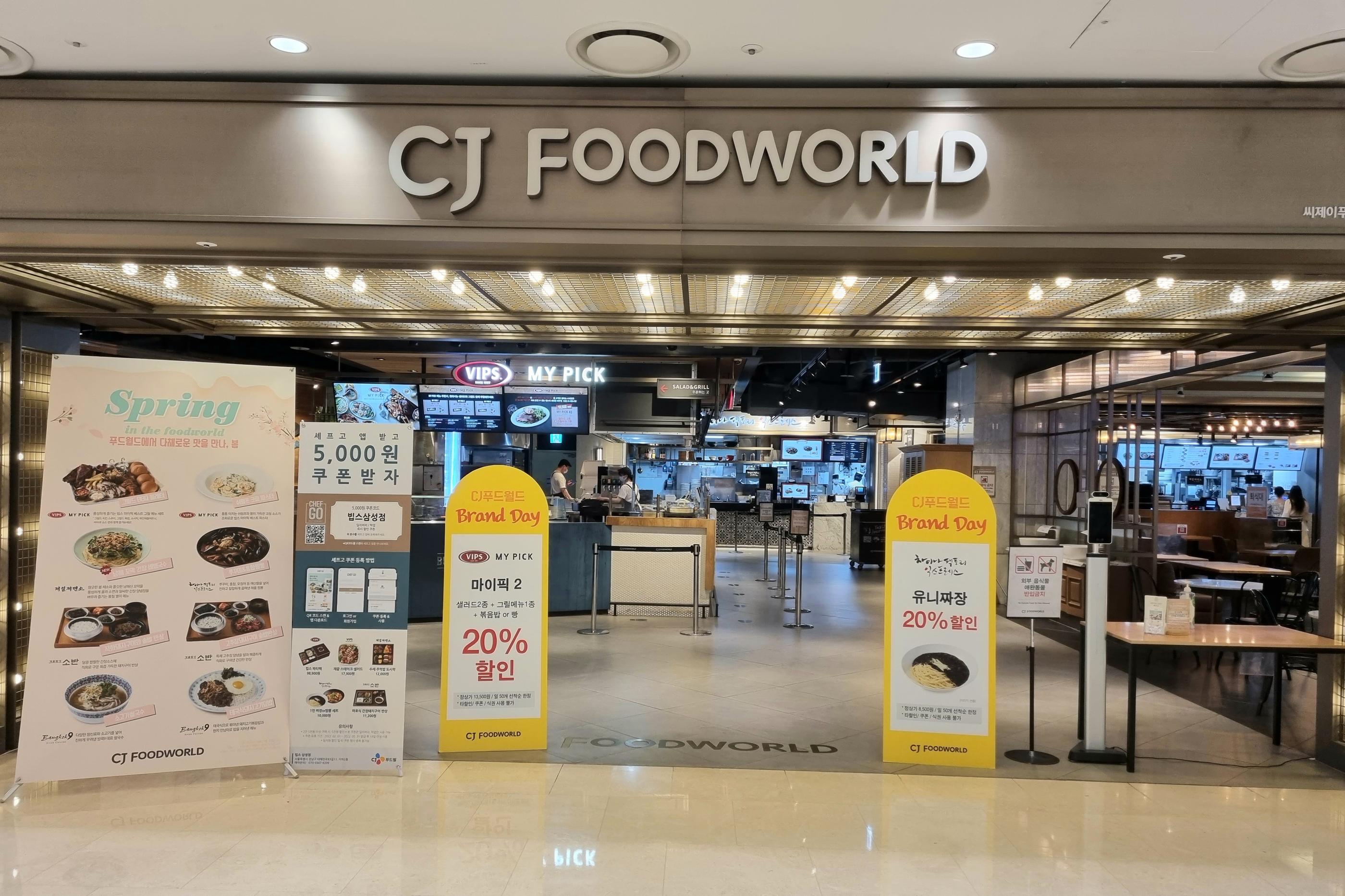 이 사진은 코엑스몰의 CJ 푸드월드를 특징으로 하며, 식사를 하려는 이들로 북적거리는 모습을 보여준다. 넓은 실내와 깔끔한 인테리어는 즐거운 식사 시간을 제공하며, 다양한 음식점들이 한곳에 모여있다.