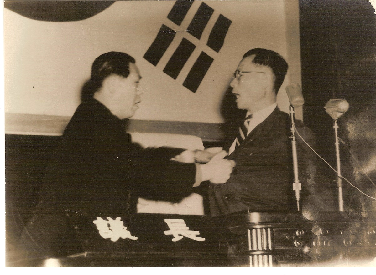 1954年韓國四捨五入改憲案通過後的議員會議場景，手持文件的議員在展示內容。