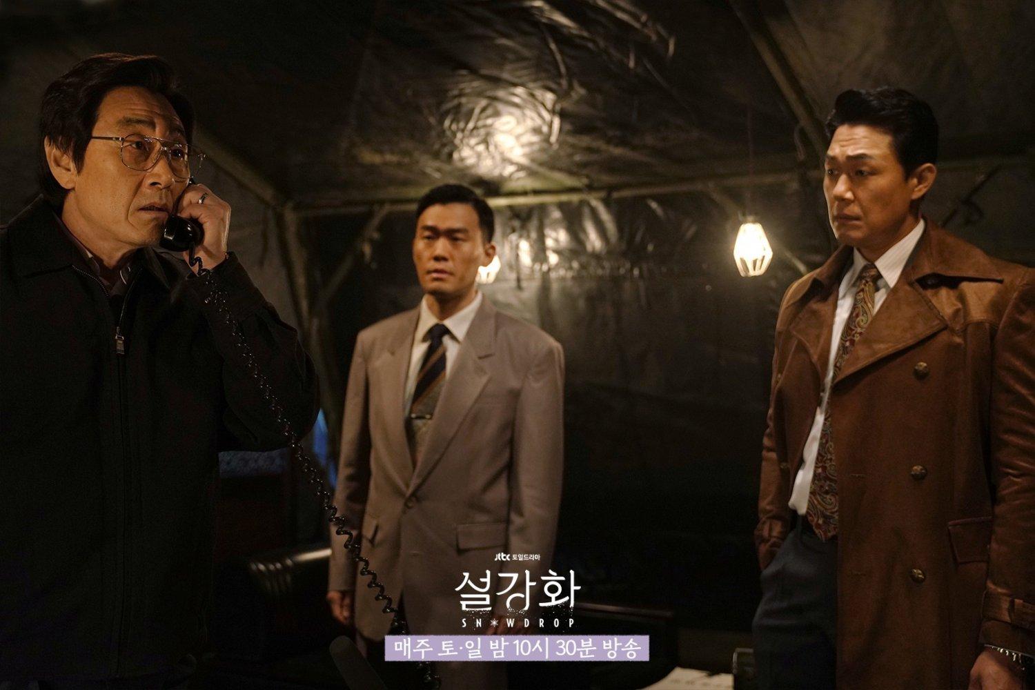 ตัวละครในชุดสูทอยู่ในเต็นท์มืดมิด ฉากละครที่มีบรรยากาศตึงเครียดจากซีรีส์เกาหลี Snowdrop