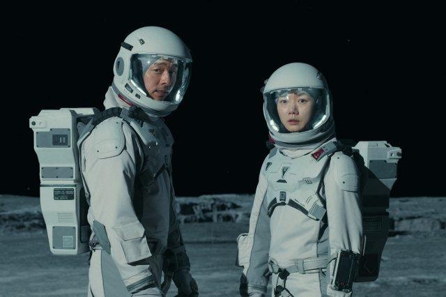 宇宙服を着た2人の俳優が月面に立っている「静かなる海」の撮影シーン。