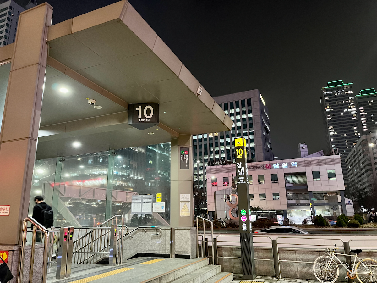 Ausgang 10 der U-Bahnstation Jamsil bei Nacht mit modernen Gebäuden.