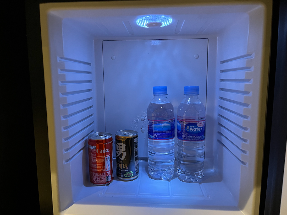 Kleiner Kühlschrank mit Wasserflaschen und Getränken im Hotelzimmer.
