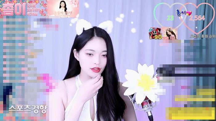 ソミが白い衣装で耳飾りを付け、ライブ放送を行っているシーン。