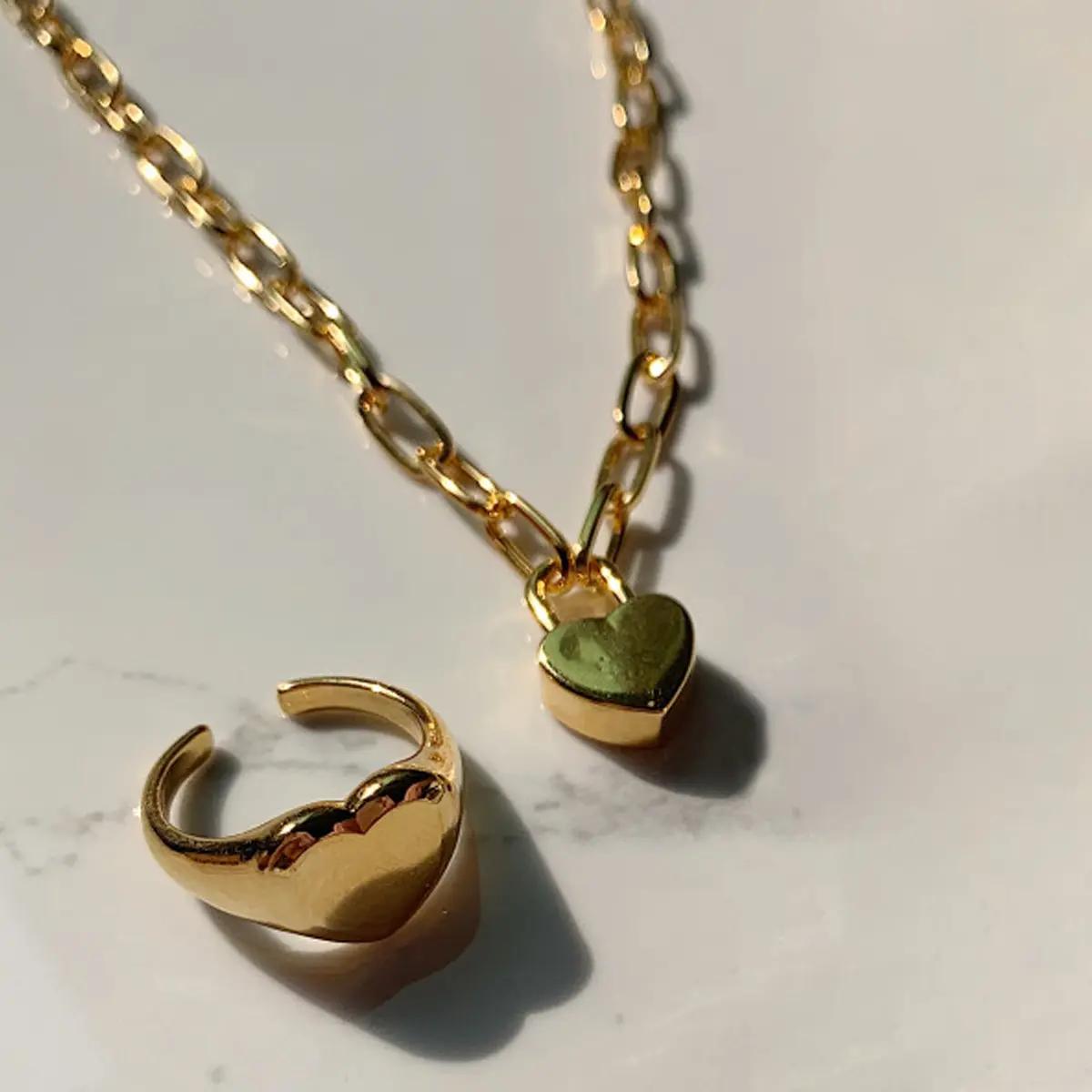 Set perhiasan emas yang terdiri dari cincin dan kalung dengan liontin hati dari koleksi justLoveR. Produk rekomendasi Song Zia.