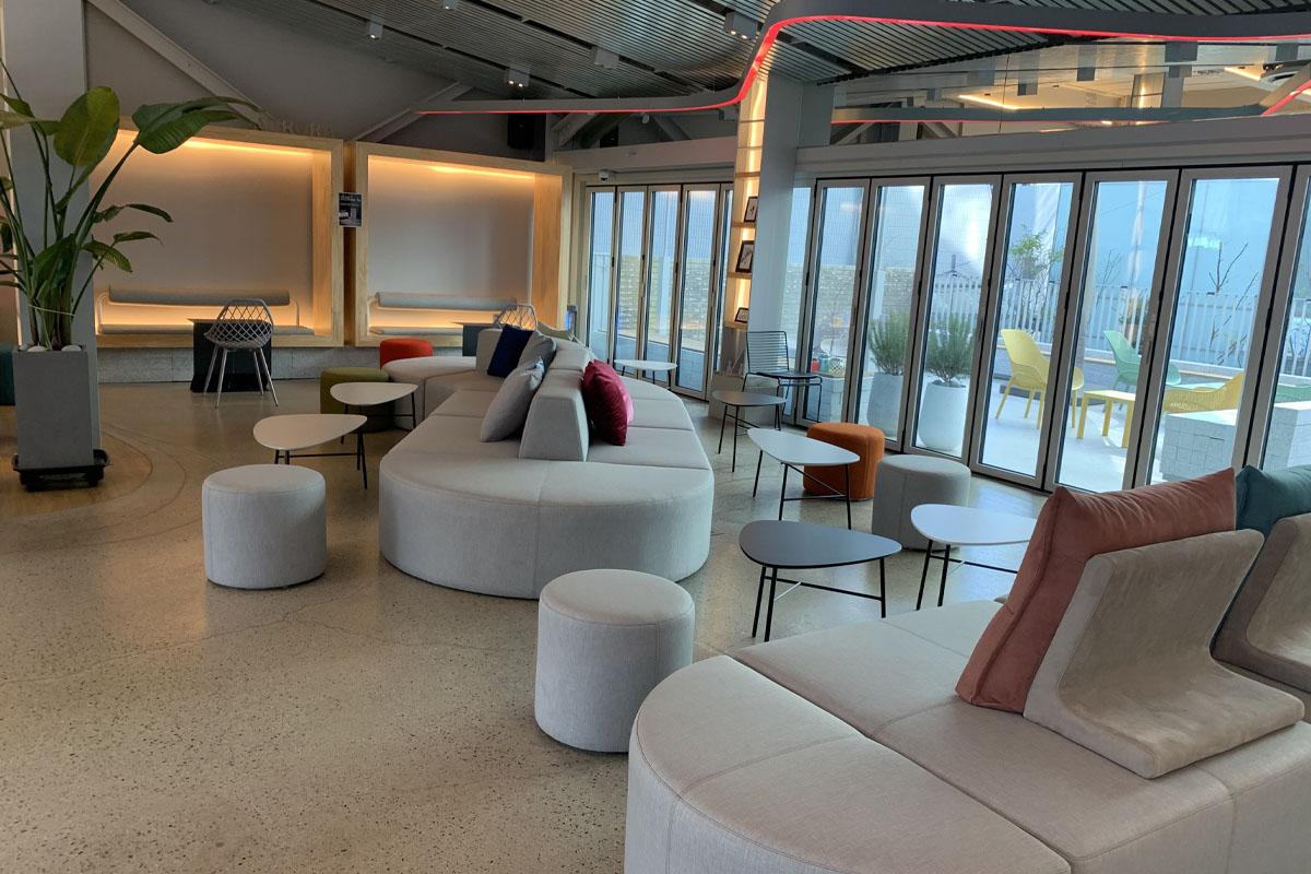 宽敞舒适的弘大AURORA咖啡厅内景，现代风格沙发和自然采光营造放松氛围。