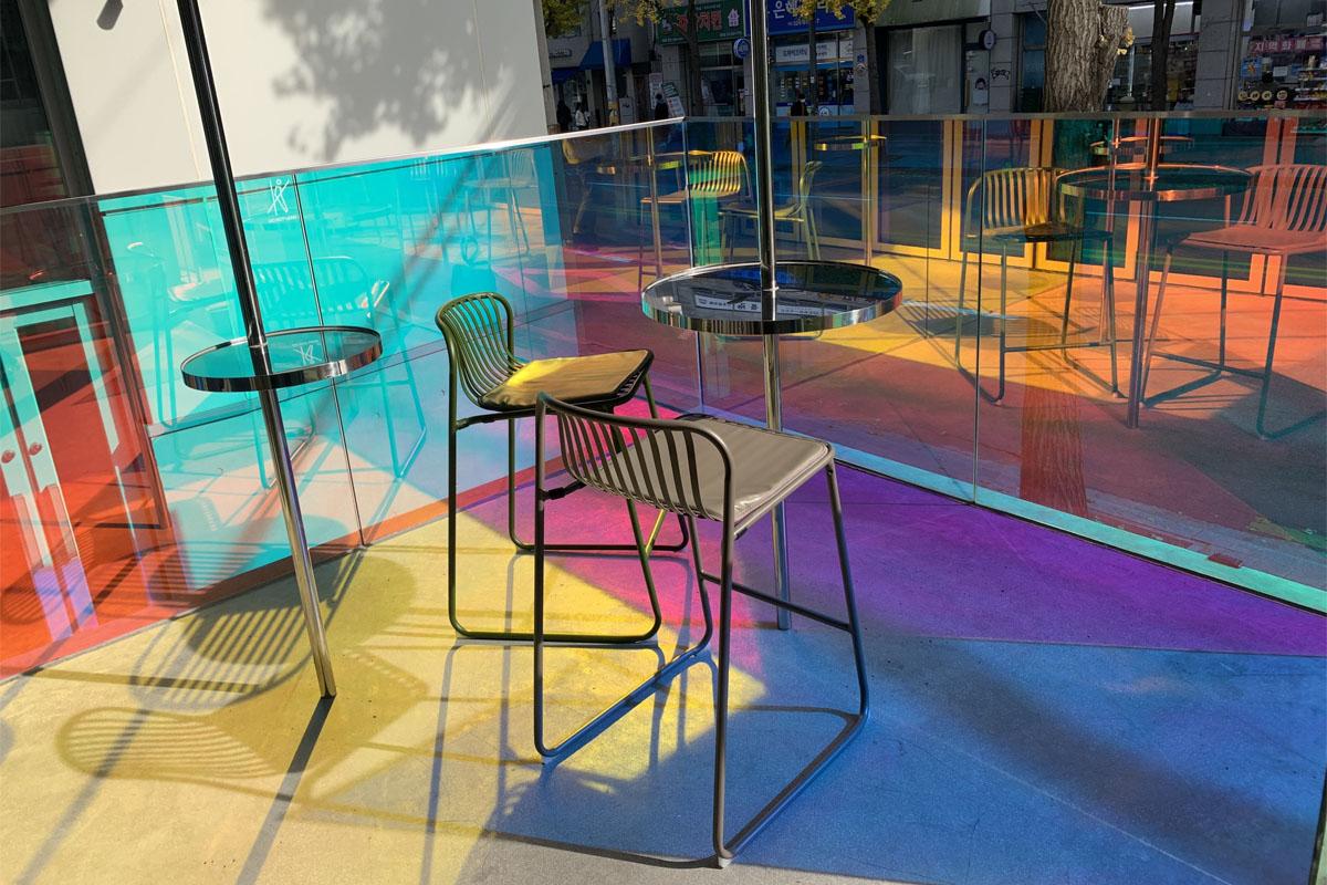 在明亮的环境下，活动隔间内的彩色椅子和桌子。