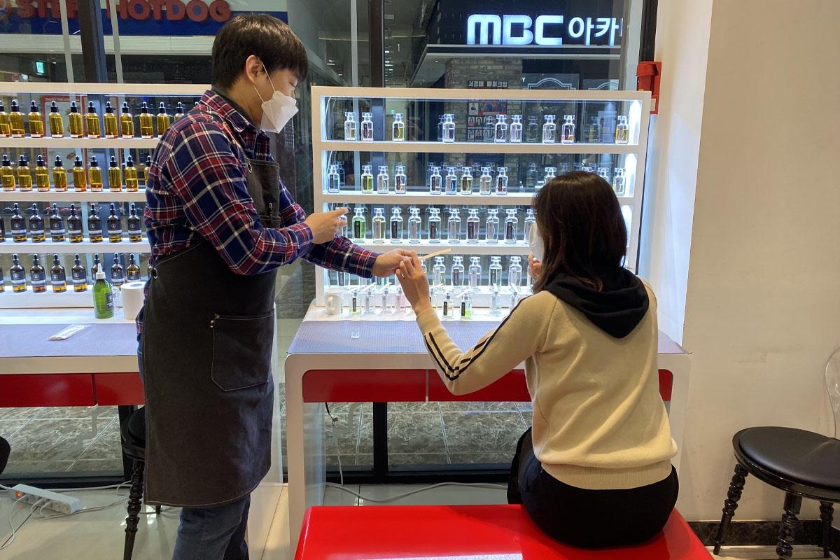 A professional perfumer assisting a customer in selecting personalized fragrances at Aroma Forest, Seoul