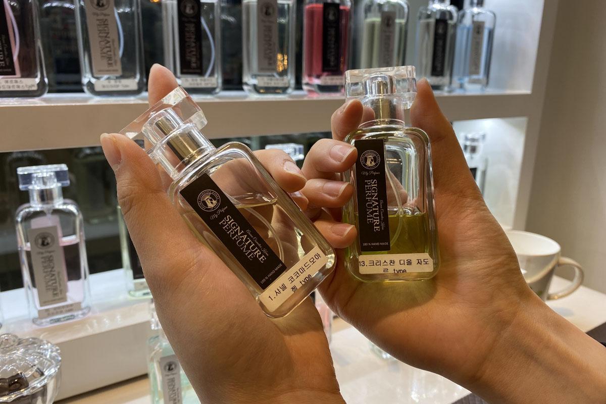 Two signature perfume bottles from Aroma Forest held in hands, showcasing bespoke fragrance options
