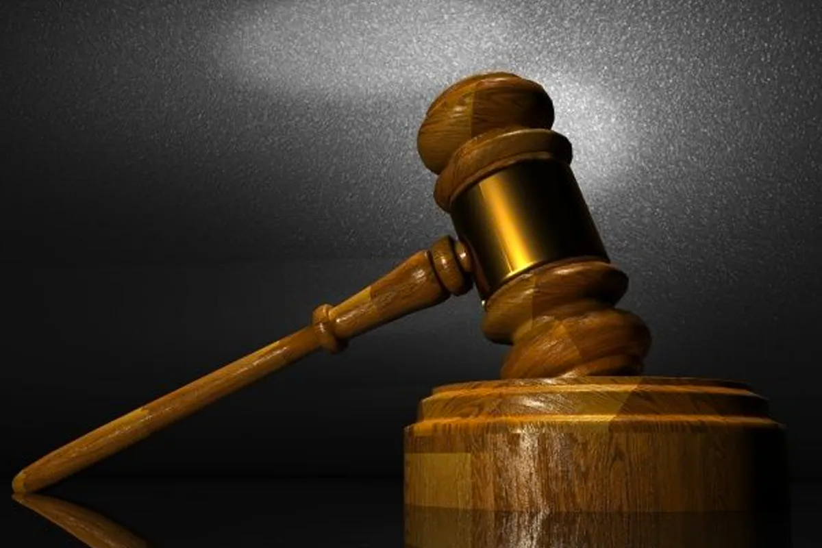 法槌放在黑色和棕色背景前，象徵法律與裁判的象徵物。