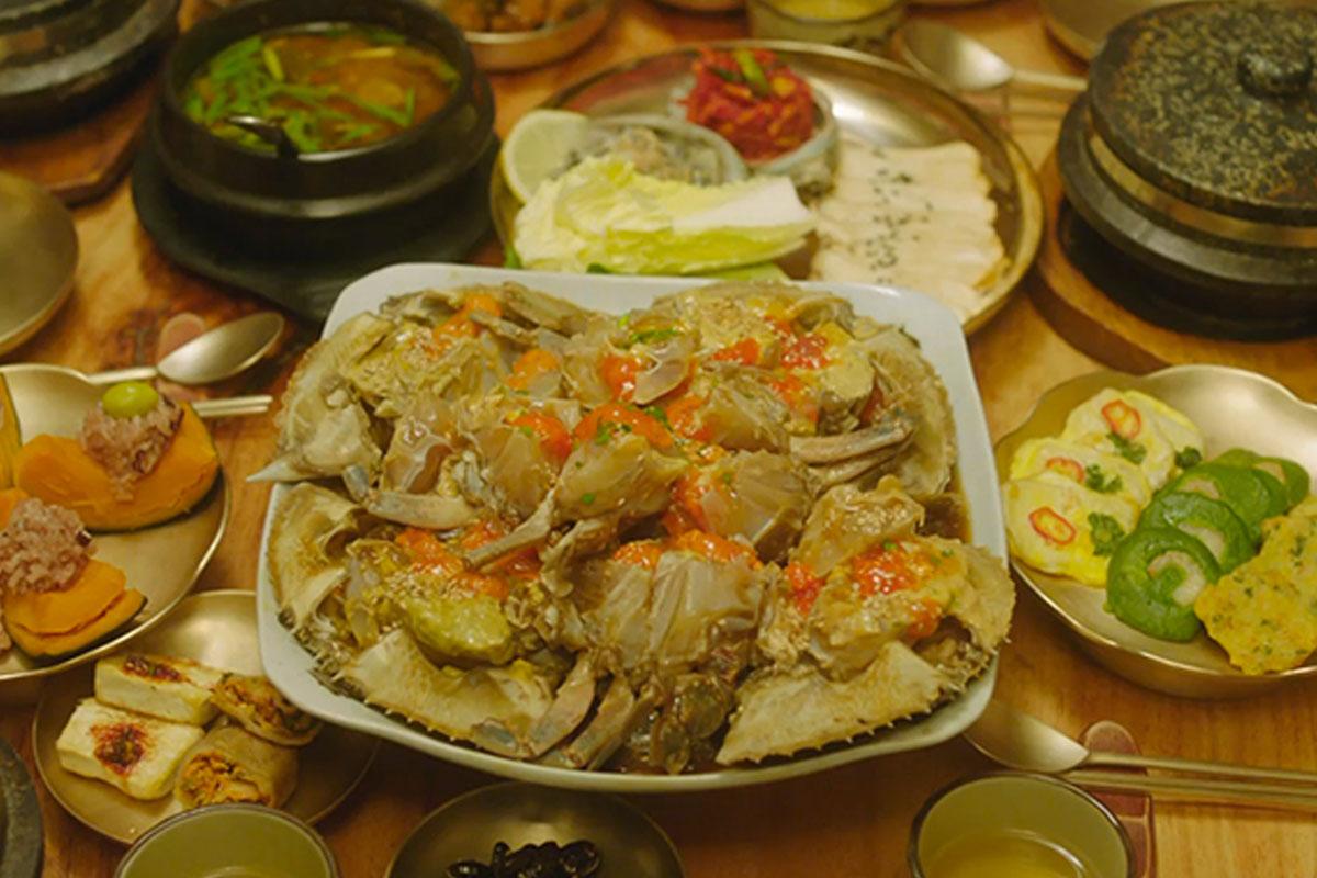 อาหารทะเลเกาหลีที่หลากหลายและน่าลิ้มลอง มีทั้งปลาดิบ กุ้ง และหอย พร้อมซอสรสอร่อยบนโต๊ะอาหาร, ล้อมรอบด้วยผักและเครื่องเคียงที่ถูกจัดอย่างสวยงามเพื่อนำเสนอคุณภาพอาหารทะเลที่เกาหลีใต้เสนอให้ชาวต่างชาติได้สัมผัส