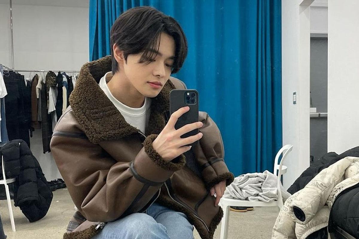 ลีโอ เทรนนีจาก Trainee A สวมเสื้อแจ็คเก็ตโค้ทขนสัตว์ถ่ายรูปเซลฟี่ด้วยโทรศัพท์มือถือ