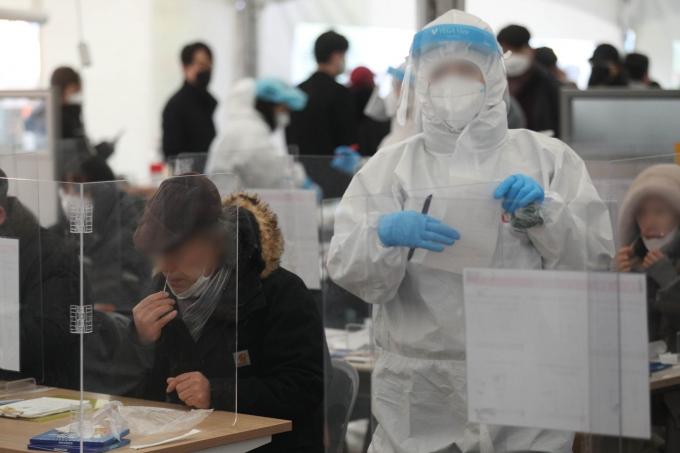 ソウル松坡区保健所の選別診療所で市民が迅速抗原検査を受けている現場。医療スタッフは感染症対策のため防護服を着用