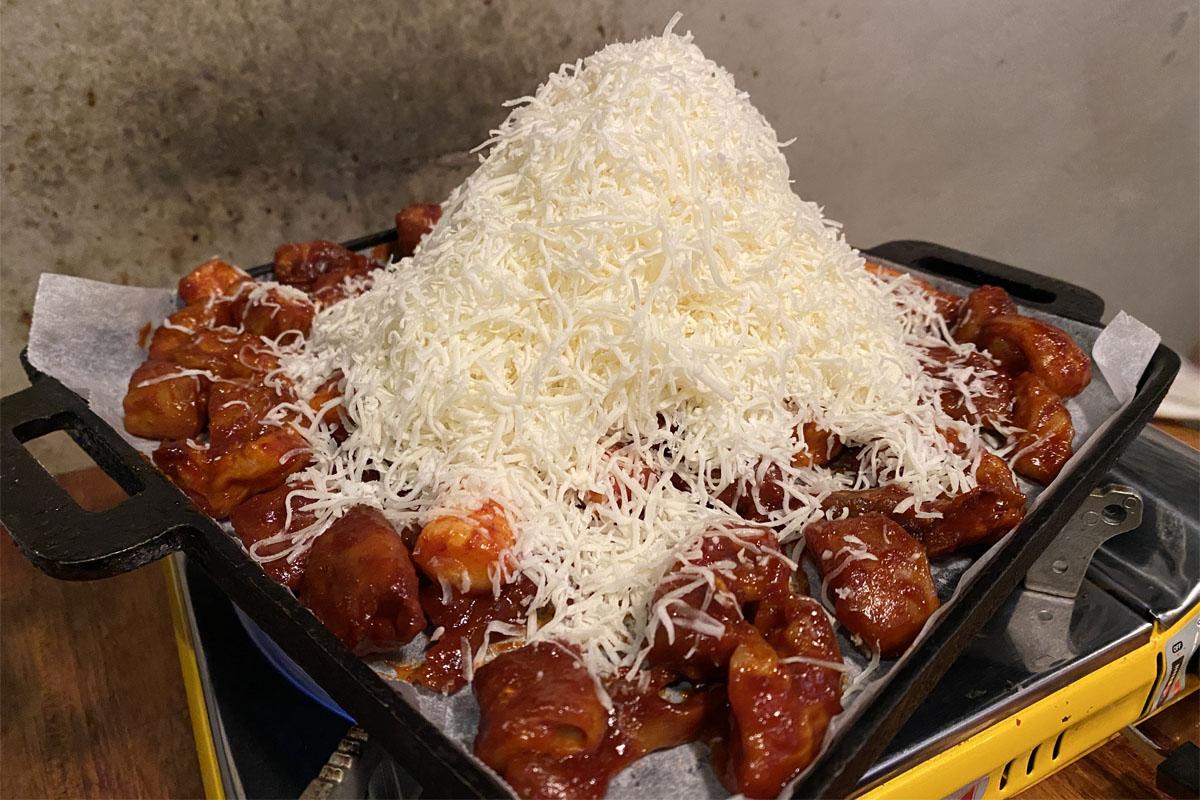 弘大飽肚烤腸主要餐點雪花大腸，覆蓋著大量白起司的特寫。