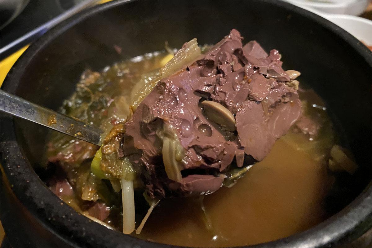 盛裝在黑色陶碗裡的牛血，為弘大飽肚烤腸的特色湯品。