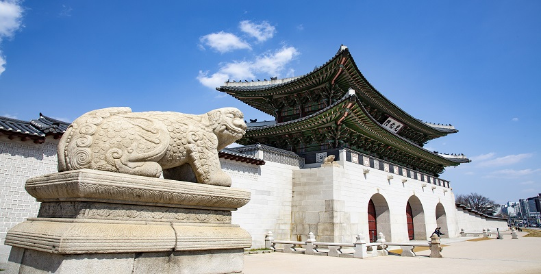 Ingresso principale del Palazzo Gyeongbokgung di Seoul con il leone di pietra e cielo limpido sopra.