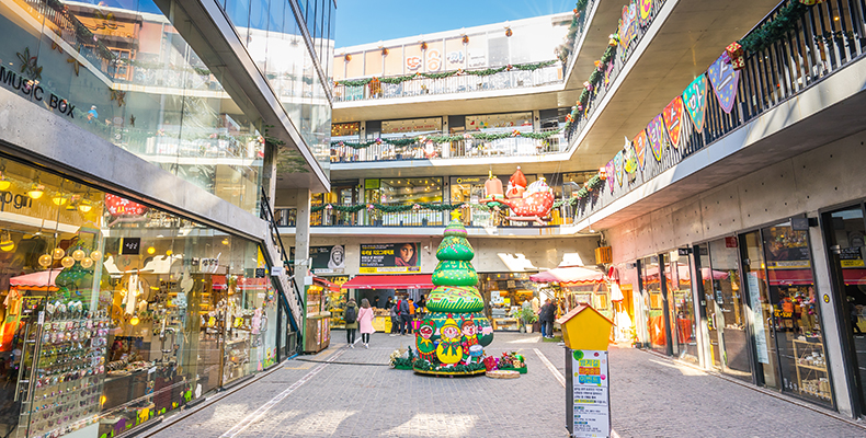 Vista diurne di un centro commerciale a Insadong, Seoul, con decorazioni colorate e visitatori.