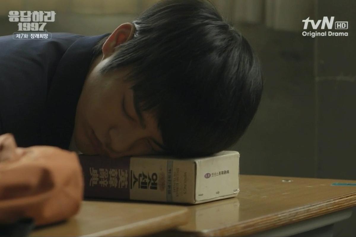 韩剧《请回答1997》的一幕，学生在教室的课桌上睡觉，表现了典型的困倦学生形象。