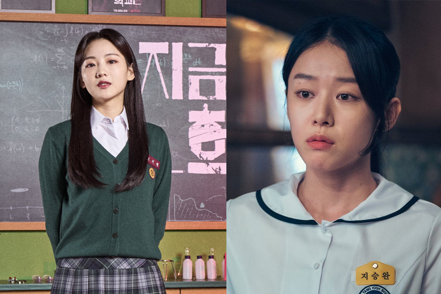 教室里的学生会长穿着校服，站在黑板前，展示出领导能力和自信的姿态。