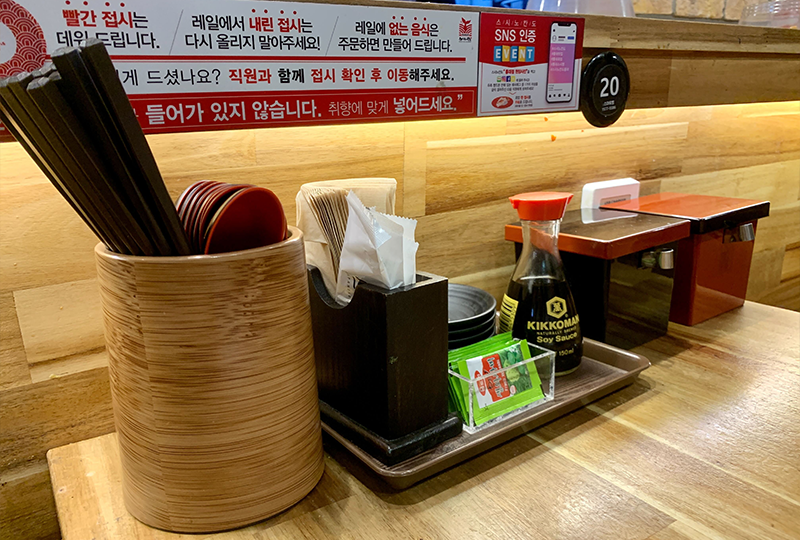 壽司店內桌面的調料區，配有醬油、筷子與其它必要調料。