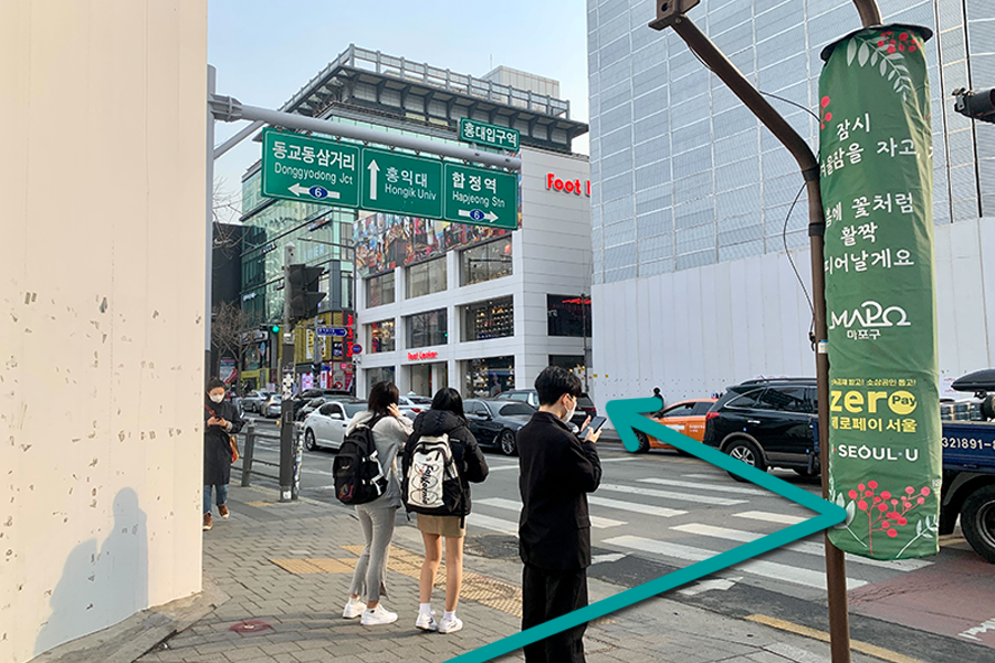 指示圖標示出了從大街上的轉角處進入弘大商圈的路徑，方便遊客找到Sushi Nokando。