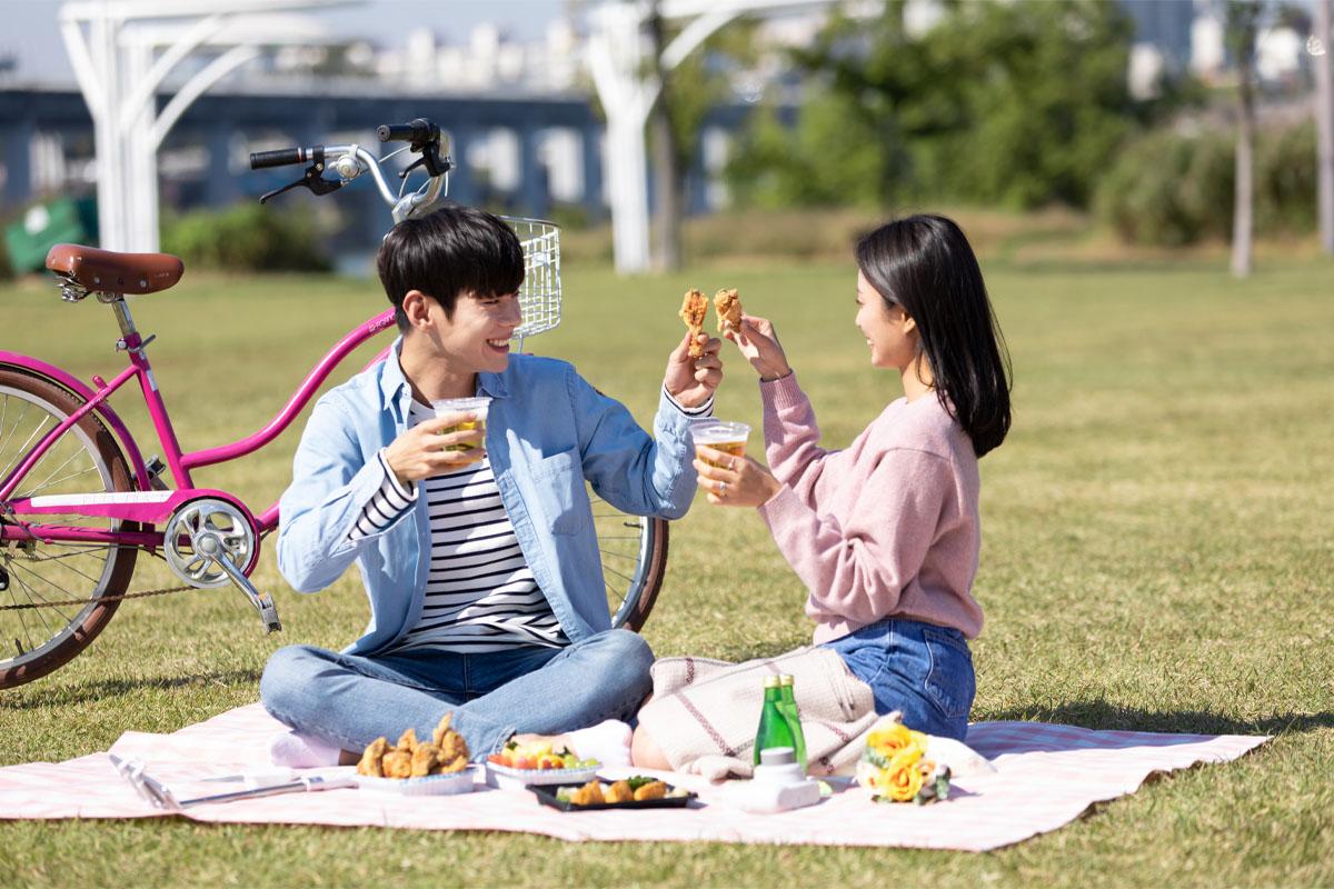 ピクニックでチキンとビールを楽しむシチェーションが写った韓国のカップル写真