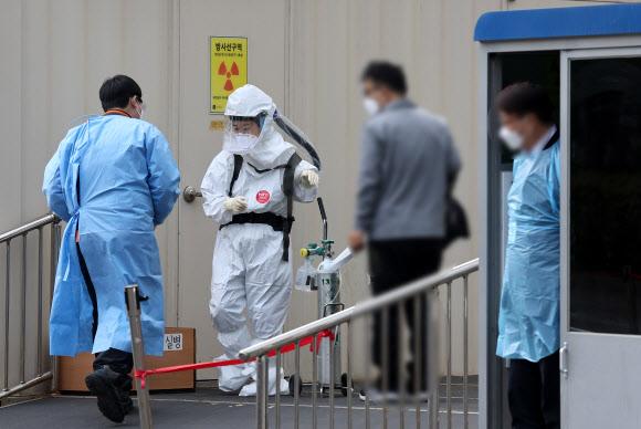 ソウル医療院で防護服を着た医療従事者がコロナ19患者の移送に備えている様子