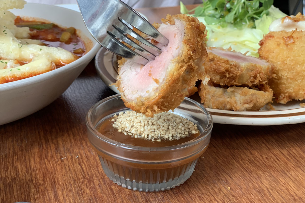 Queso mozzarella frito servido con salsa, presentando su dorado crujiente en el restaurante Happy Cheese Smile.