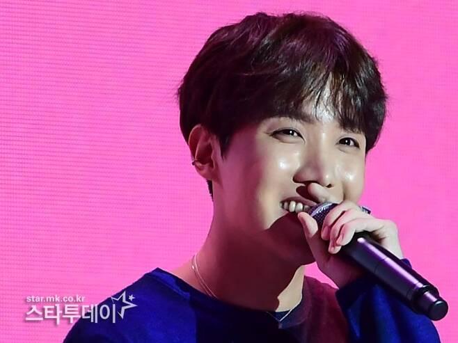 スタートゥデイでマイクを持つBTSメンバーJ-HOPEの様子（顔部分にはぼかしが入っている）