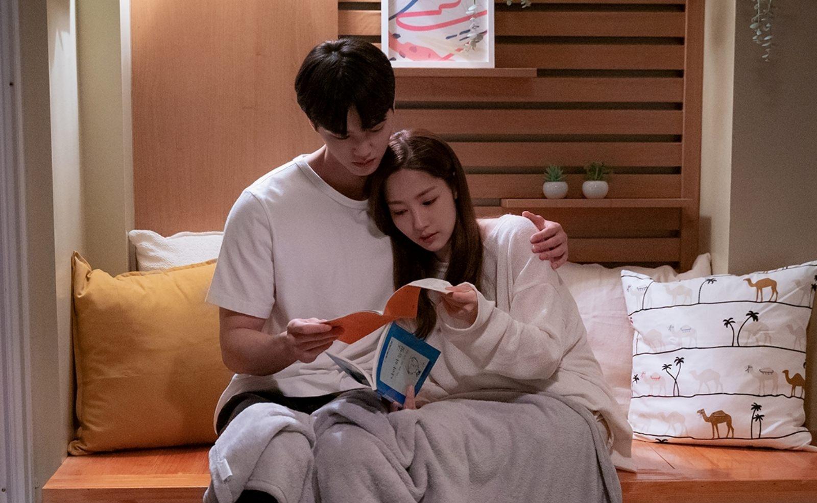 韓国ドラマの家庭的な場面。ソファに座って本を読むカップルの様子がアットホームな雰囲気で描写される。
