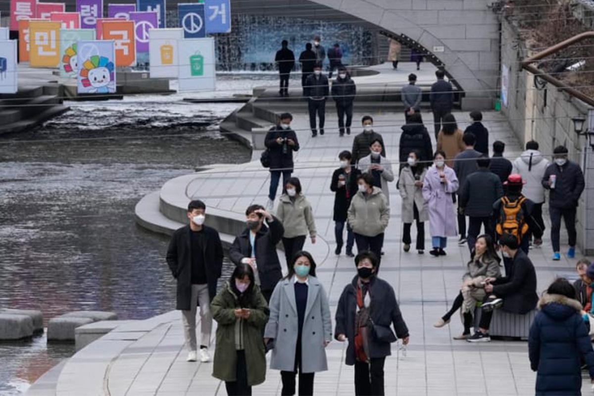 คนเดินทางบนถนนในเกาหลีใต้ โดยสวมหน้ากากป้องกันในช่วงสถานการณ์ COVID-19