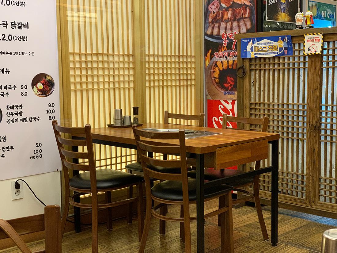 仁寺洞奉卓瓦瓮BBQ餐厅内的一张空桌,显现菜单选项和舒适的用餐环境