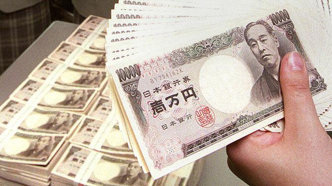 日本円の札束を持つ手、通貨の価値に関する報道を示唆