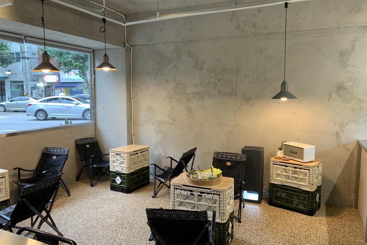 The inside decor of the cafe decorated with camping chairs and tables.