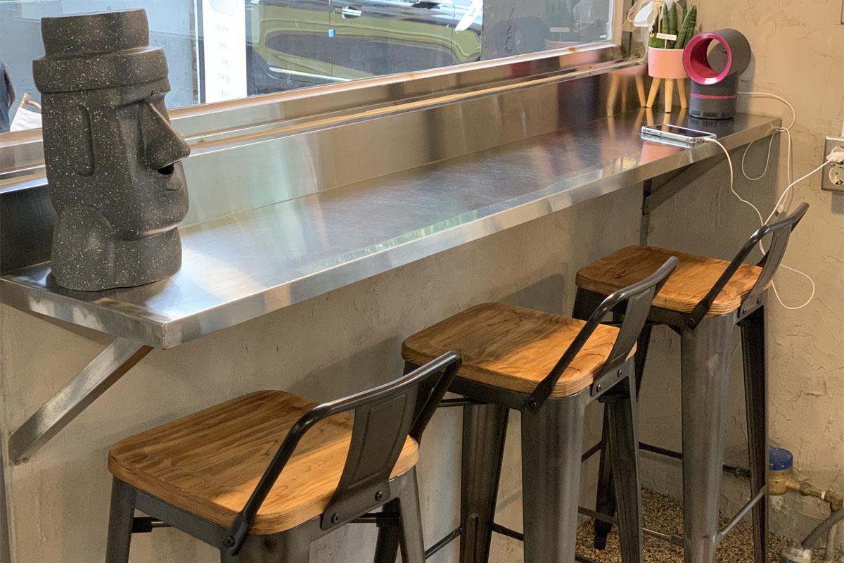 A bar seating area decorated with a Jeju-style stone statue.