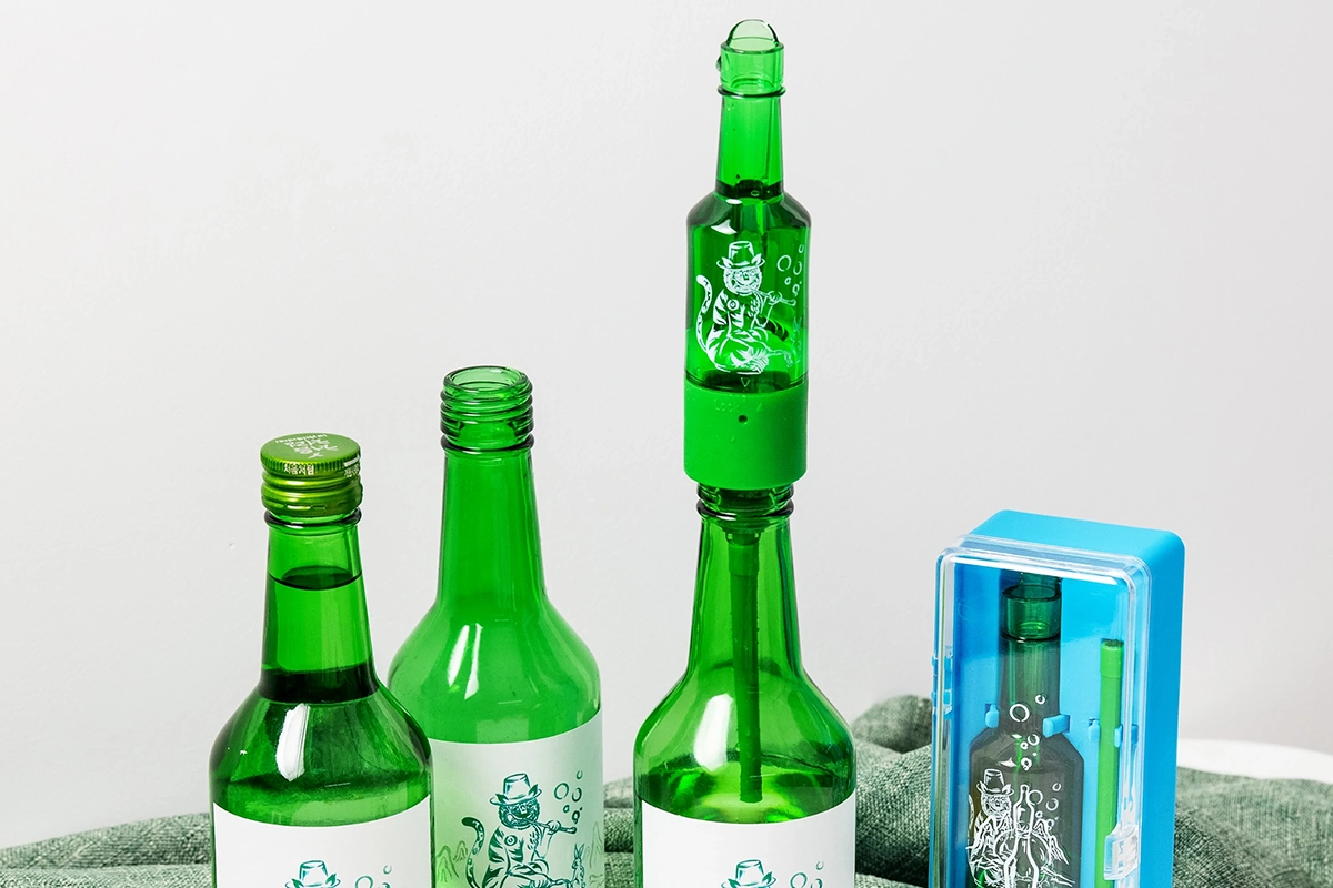 一台绿色的烧酒自动倒酒机，把绿色瓶装的烧酒自动倒入杯中，方便一人饮酒。