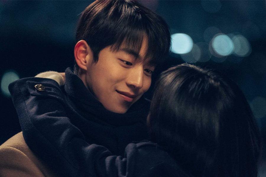 夜景下兩個年輕人親密地擁抱在一起，身後是繁華的城市燈火，展現出夜晚的浪漫與都市的喧囂。