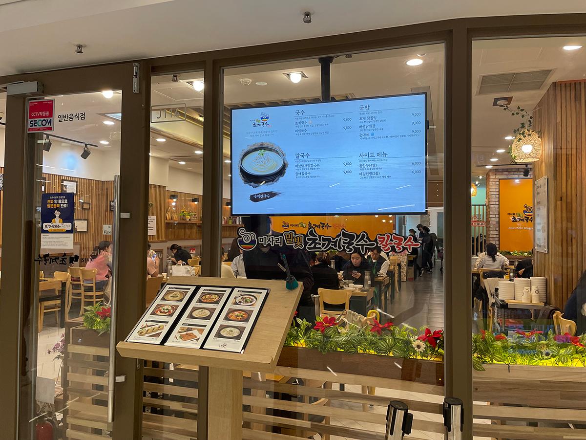 渼沙里醋鸡汤面餐厅的外观，门口展示着亮屏菜单。