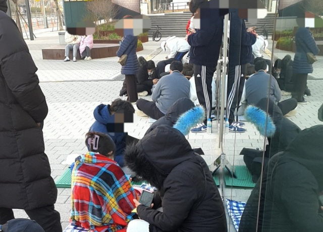 韩国消费者在商店外排队等候购买宝可梦面包的场景。