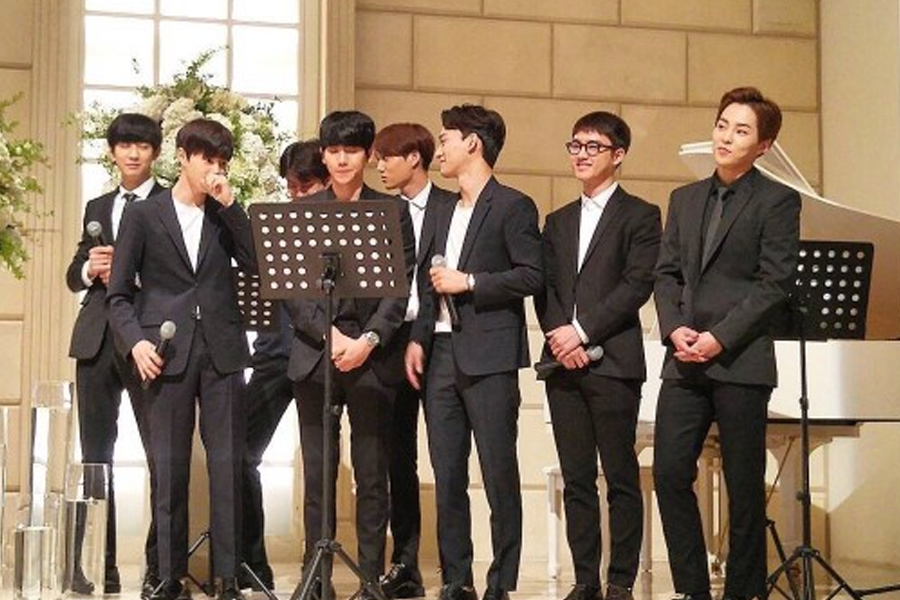 一群身穿西装的男士在婚礼上准备演唱祝歌，展示韩式婚礼上好朋友献唱的场景