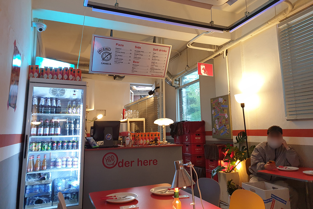 Vista notturna dell'interno di HDD Pizza, mostrando il design retrò con decorazioni sulle pareti e l'illuminazione accogliente.