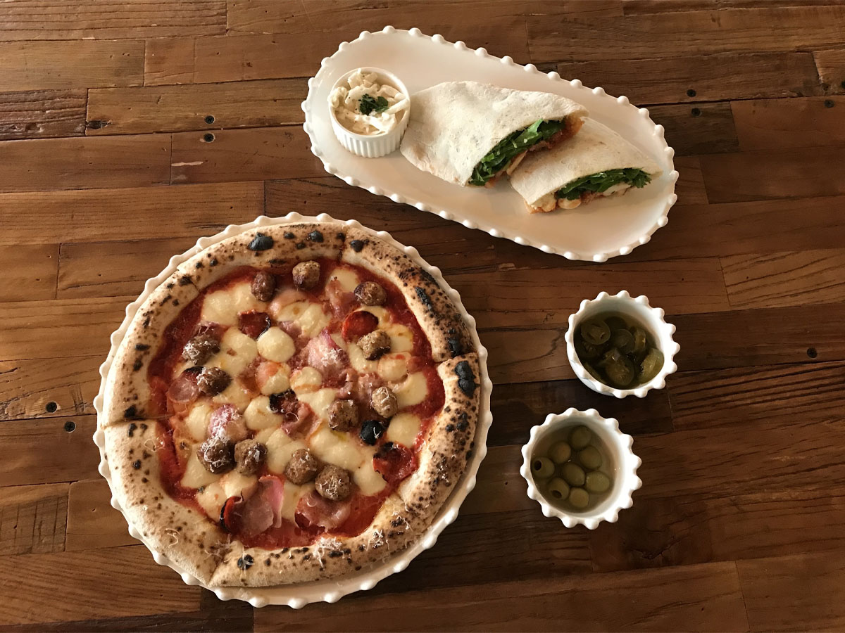 Vista aerea della pizza Fresh Meat Lover su un piatto circolare bianco.