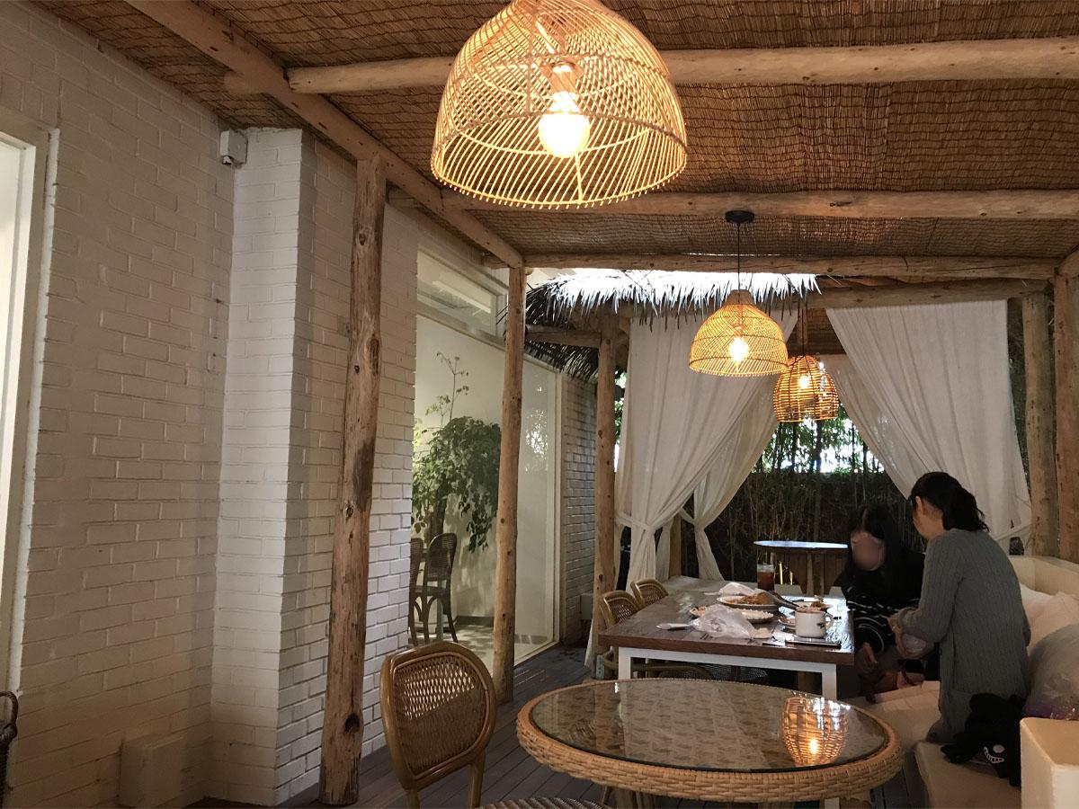 An inside view of the terrace at Wake & Bake. A rattan lamp hangs from the ceiling and points at the table.