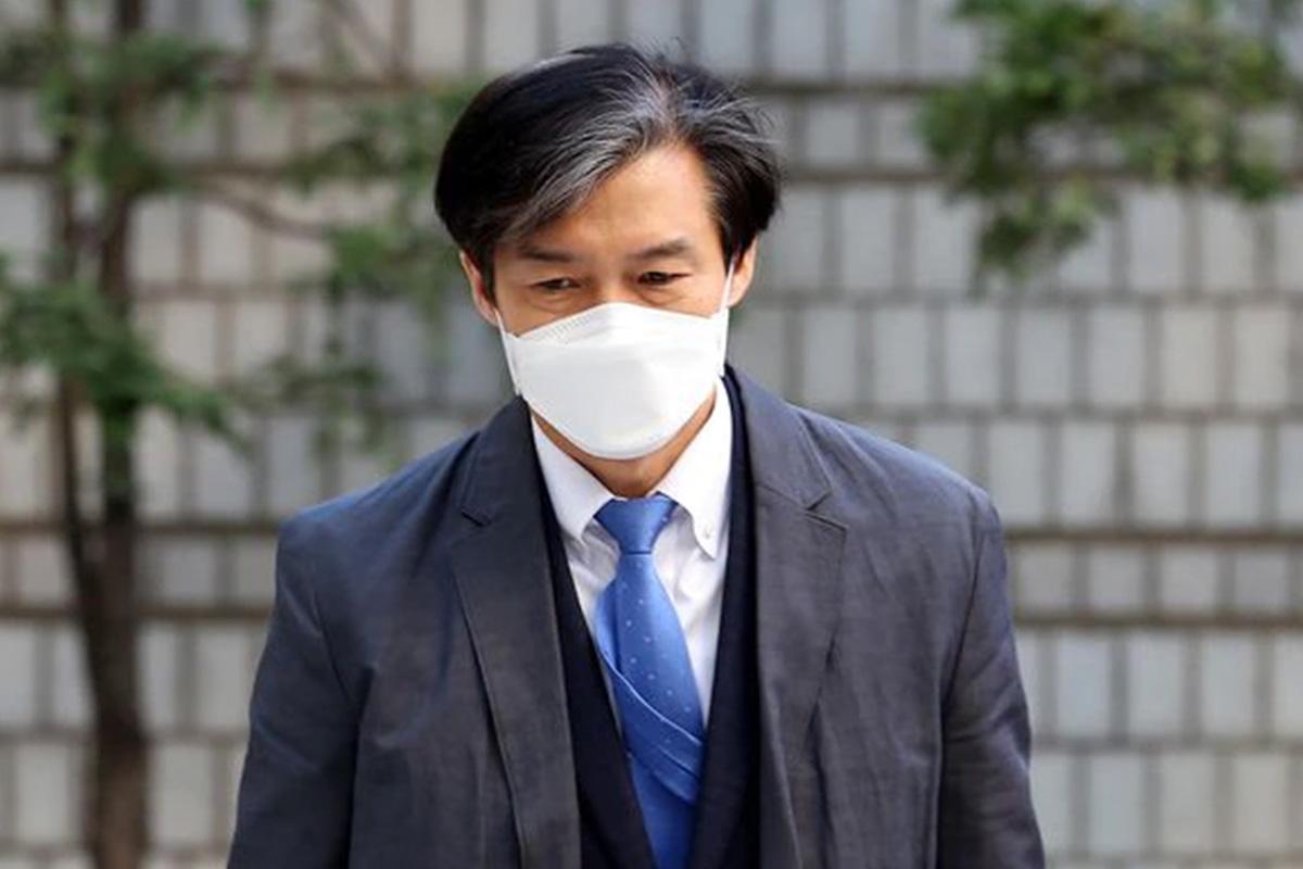 ชายใส่สูทที่มีใบหน้าเบลอซึ่งสวมเนคไทสีฟ้า แสดงถึงบุคคลในข่าวเกี่ยวกับการทุจริตทางการศึกษาในเกาหลี