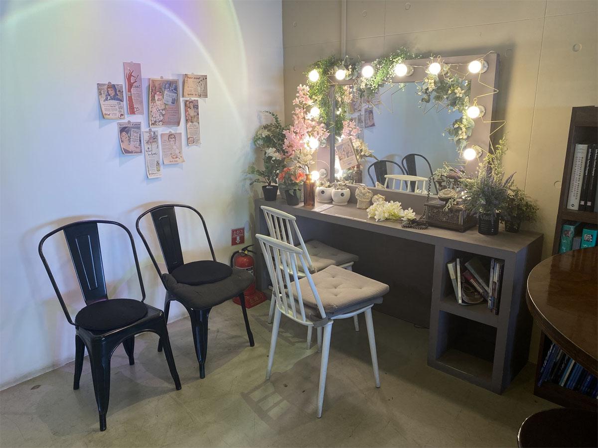Coin de photo dans le café Caisson 24 avec un miroir de style loge et des décorations florales.