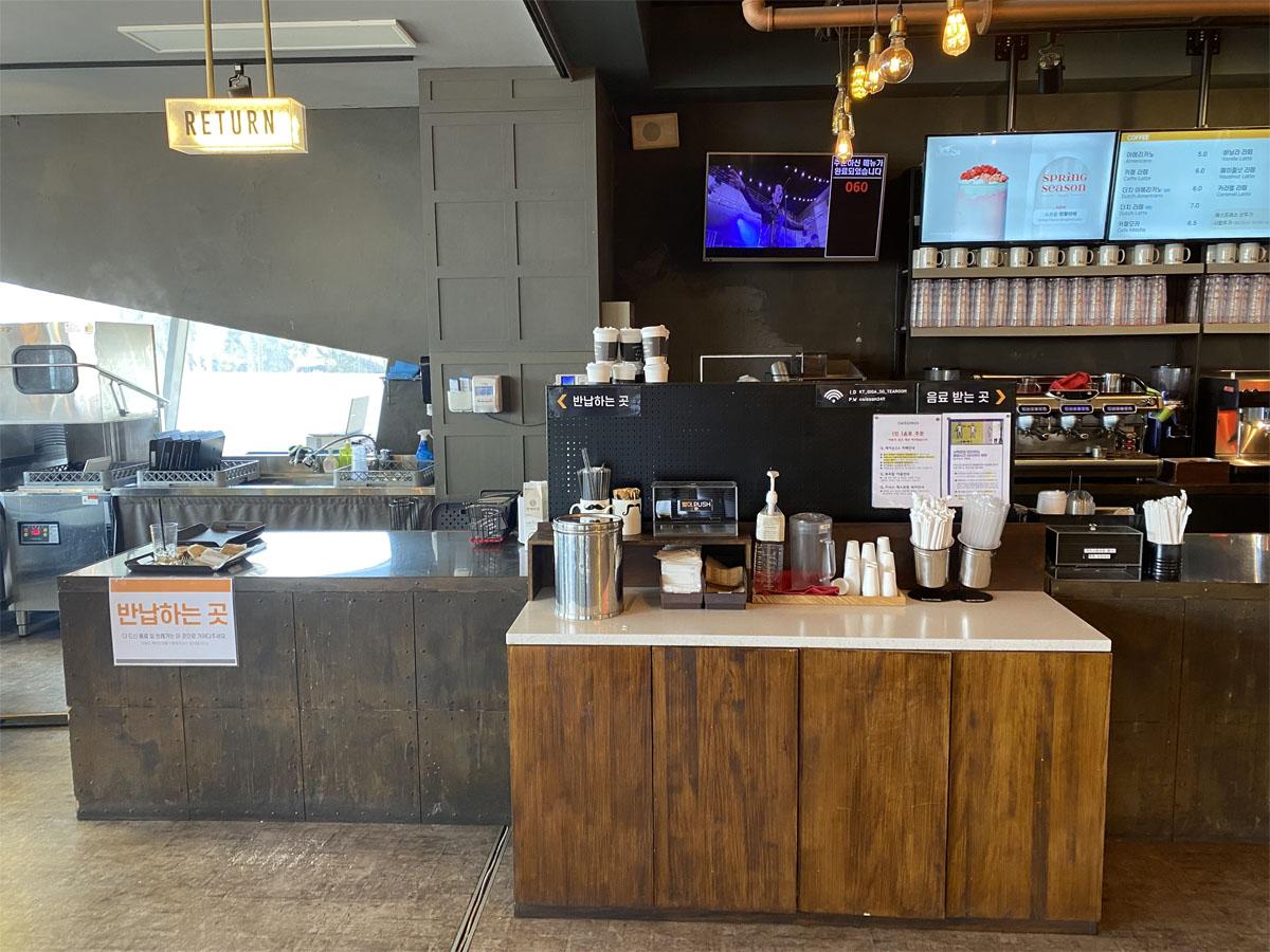 Bar à retour de plateaux vide au café Caisson 24, prêt à accueillir les assiettes et ustensiles après utilisation.