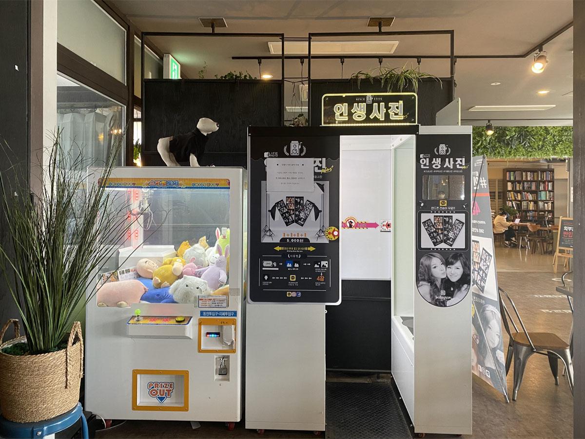 Cabine photo et machine à peluches dans l'intérieur du café Caisson 24.