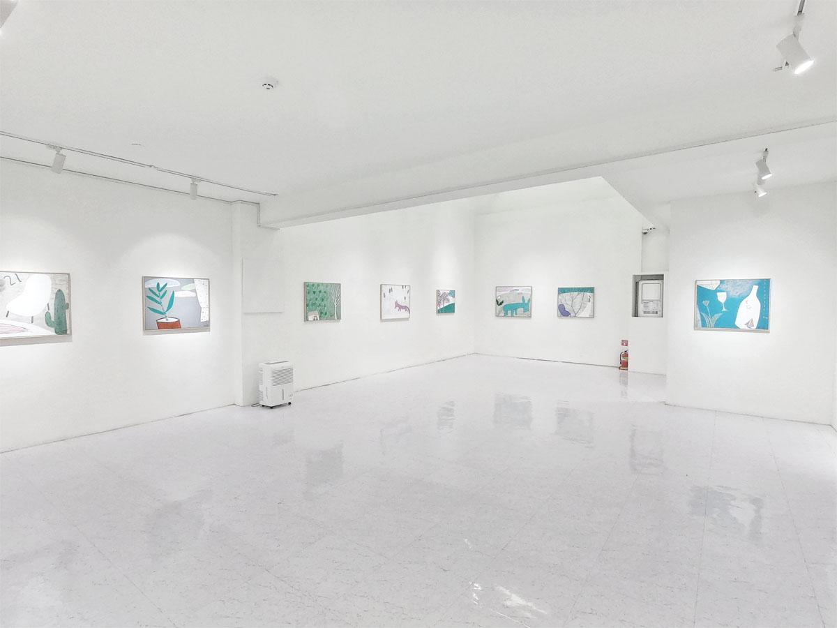 Vue intérieure d'une galerie d'art blanche au sous-sol du café Caisson 24.