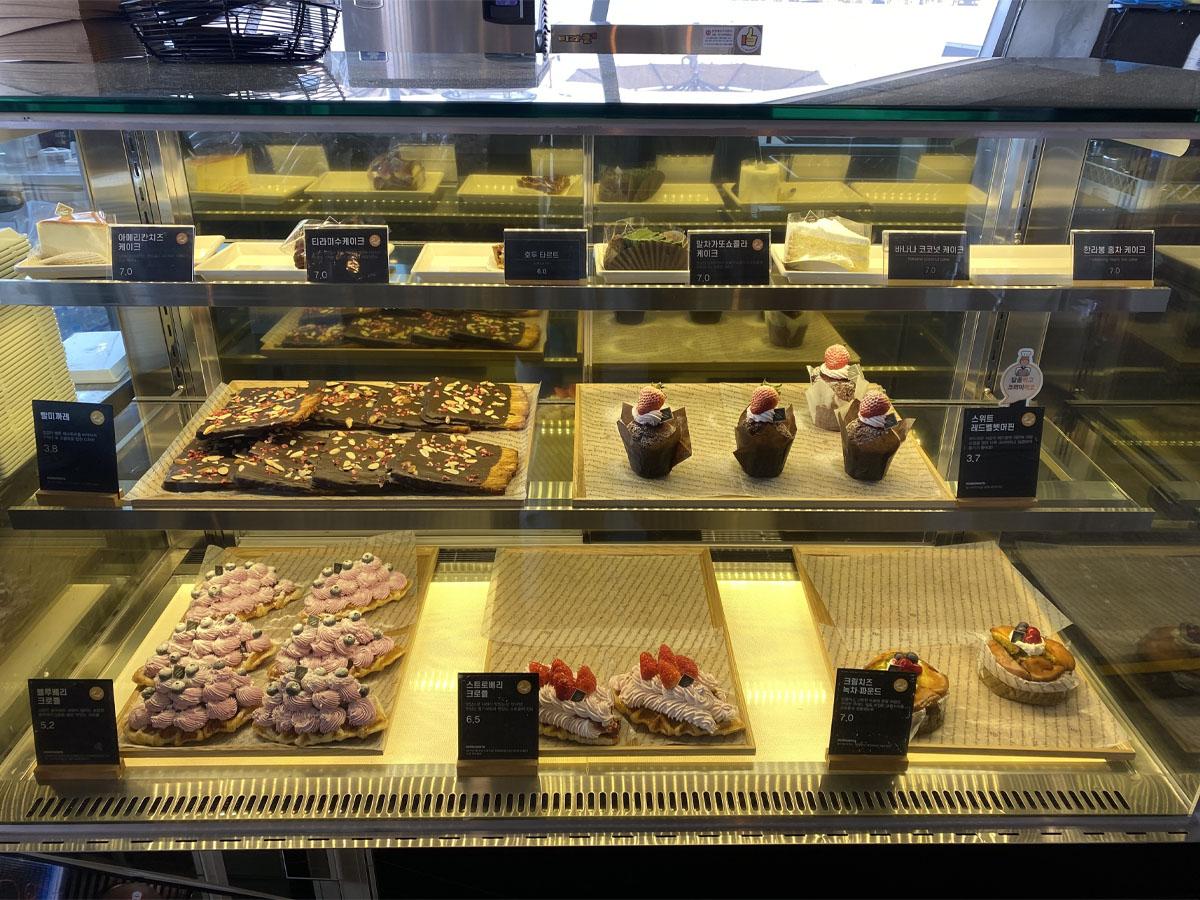 Vitrine réfrigérée du café Caisson 24 avec une sélection de desserts et pâtisseries.